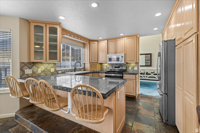 19 South 820 East Tooele, UT 84074 - Photo 4 of 46 Kitchen with light wood finish cabinetry, a kitchen breakfast bar, appliances, a peninsula, and recessed lighting