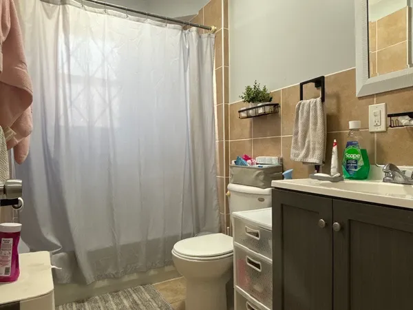 a bathroom with a sink a toilet and shower curtain