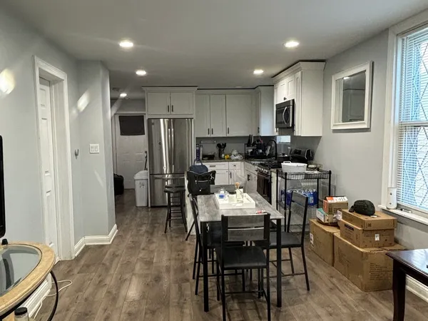a kitchen with a dining table chairs and refrigerator