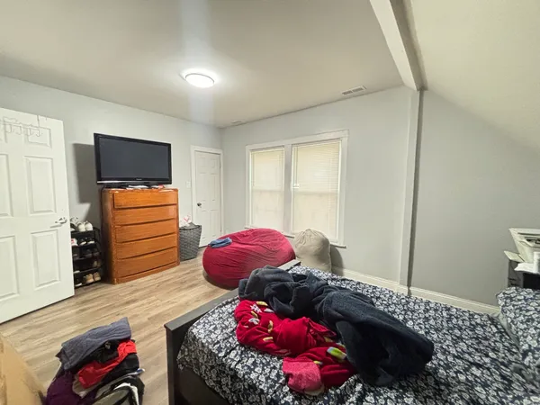 a bedroom with a bed and wooden floor