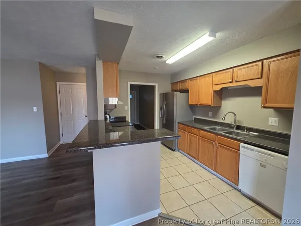 a large kitchen with granite countertop a stove and a sink