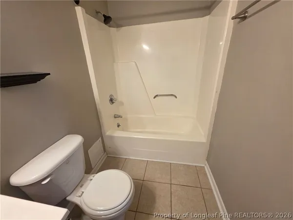 a white toilet sitting next to a bath tub