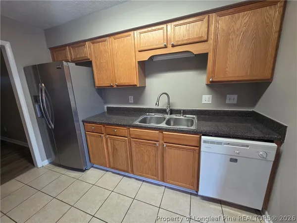 a kitchen with granite countertop a refrigerator and a sink