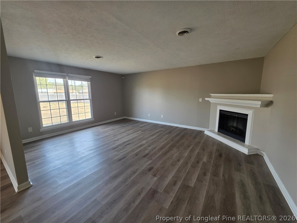 6536 Grist Mill Road Fayetteville, NC 28314 - Photo 8 of 23 a view of empty room with wooden floor and fireplace