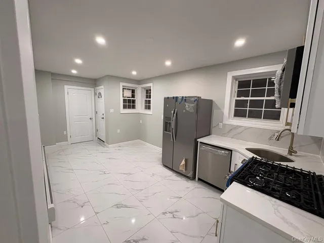 a kitchen with a refrigerator and a stove top oven