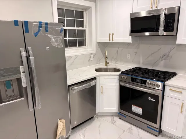 a kitchen with stainless steel appliances a stove a microwave and a sink