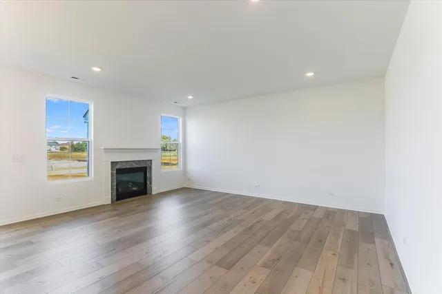 a view of empty room with wooden floor and fireplace