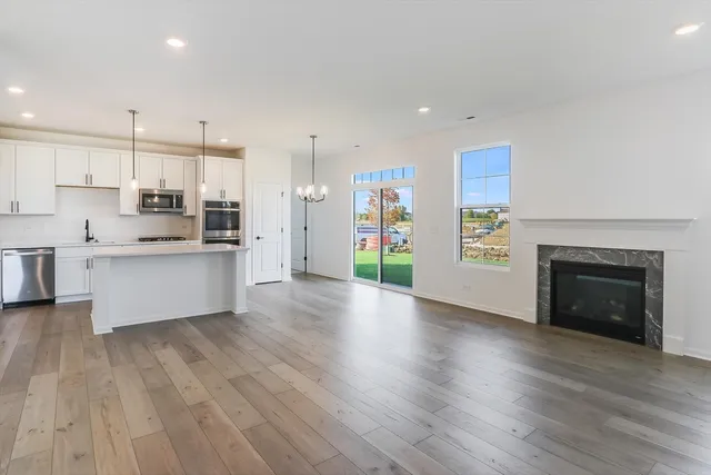 a large kitchen with stainless steel appliances granite countertop a wooden floors and a fireplace