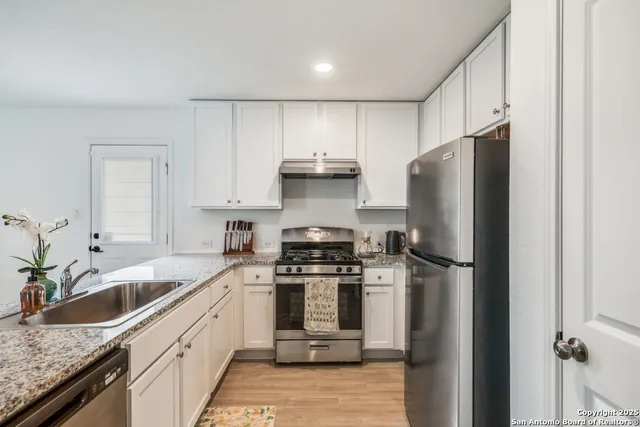 a kitchen with stainless steel appliances granite countertop a refrigerator stove and sink