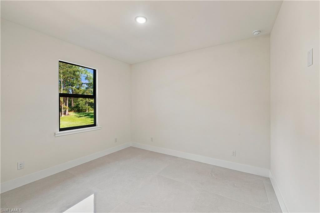 183 5th Street Southwest Naples, FL 34117 - Photo 26 of 40 Recessed ceiling lighting, a single window with black framing, and neutral-toned wall paint