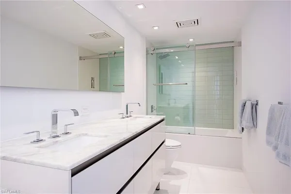 a bathroom with a sink tub vanity and a mirror
