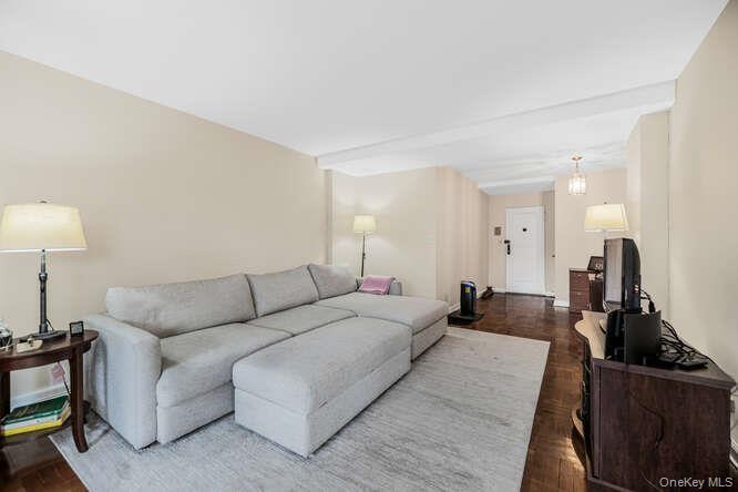 235 Garth Road, Unit E5I Scarsdale, NY 10583 - Photo 12 of 22 a living room with furniture a lamp and a flat screen tv