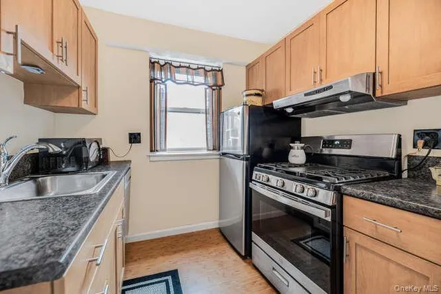 a kitchen with granite countertop a sink stove and cabinets