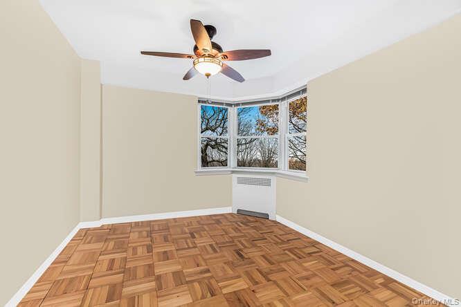 235 Garth Road, Unit E5I Scarsdale, NY 10583 - Photo 10 of 22 a view of empty room with wooden floor and fan