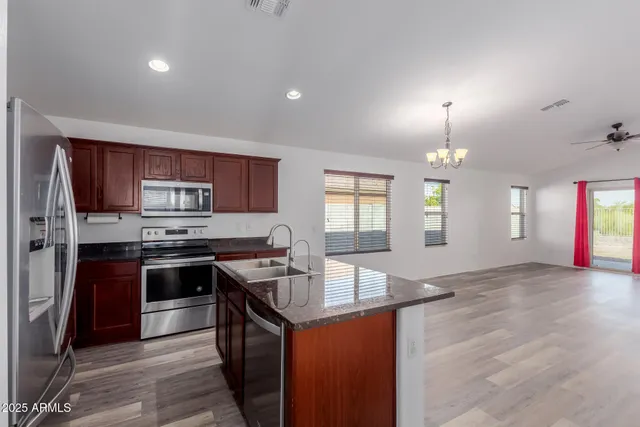 a kitchen with stainless steel appliances granite countertop a sink stove and refrigerator