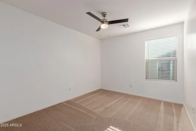 a view of empty room with wooden floor and window