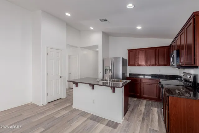 a kitchen with stainless steel appliances granite countertop a stove a sink and a refrigerator