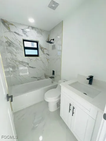 an empty room with windows and ceiling fan