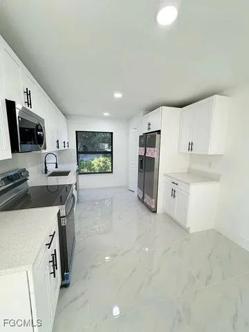 a spacious bathroom with a granite countertop sink a toilet a mirror and shower