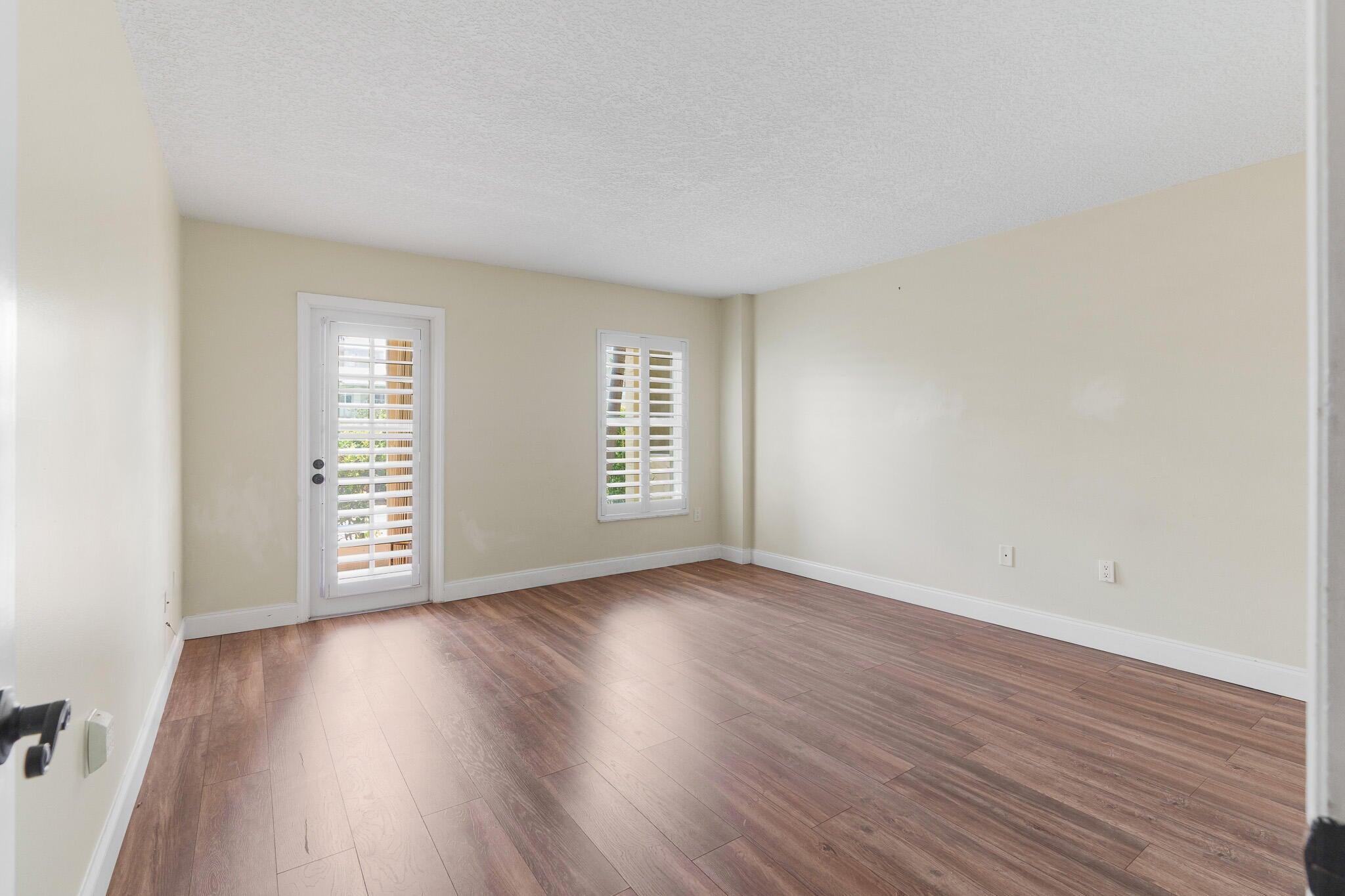 951 De Soto Road, Unit 130 Boca Raton, FL 33432 - Photo 11 of 38 an empty room with wooden floor and windows