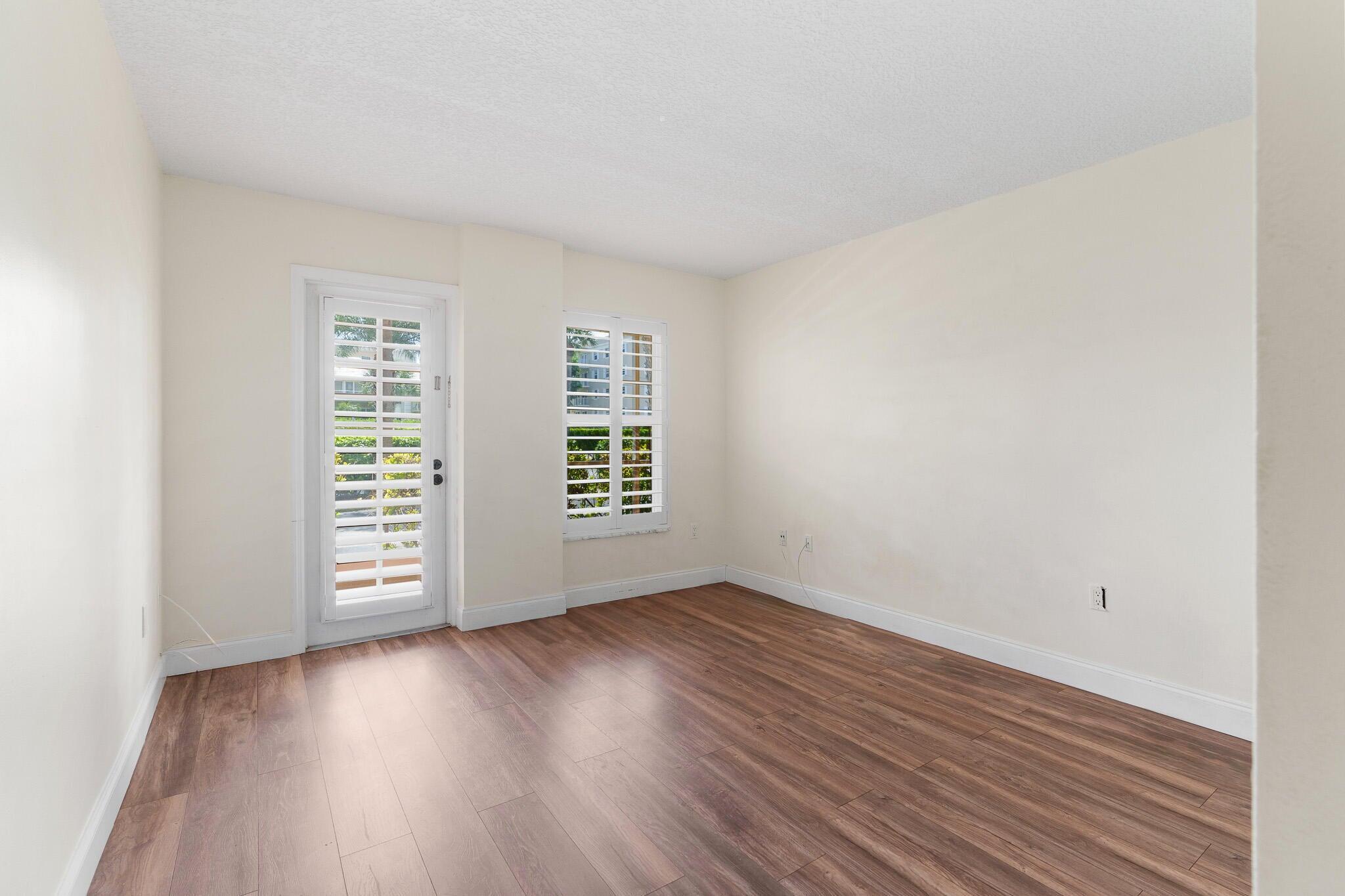 951 De Soto Road, Unit 130 Boca Raton, FL 33432 - Photo 18 of 38 an empty room with wooden floor and windows