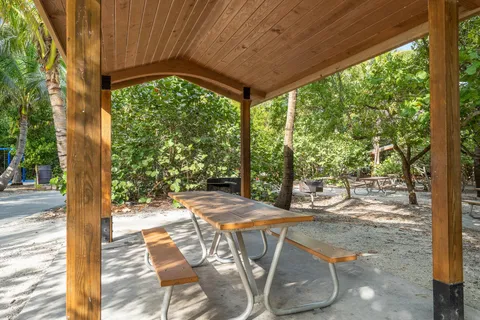 a view of a patio with table and chairs potted plants with wooden floor and fence