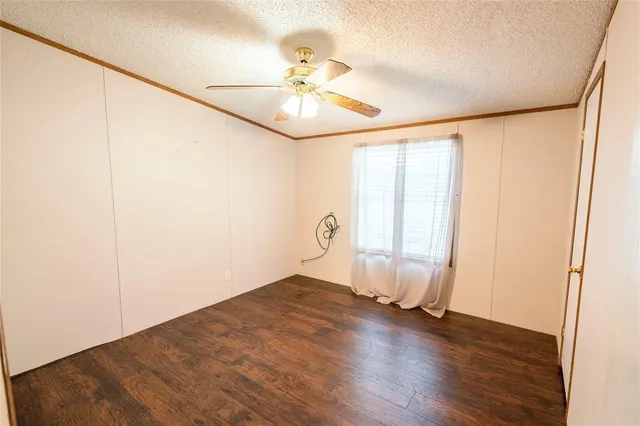 a view of a room with wooden floor and a ceiling fan