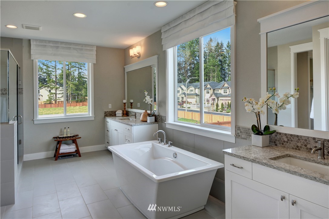 258 Field Place Southeast Renton, WA 98059 - Photo 12 of 19 a spacious bathroom with sink a mirror a bathtub and next to a window