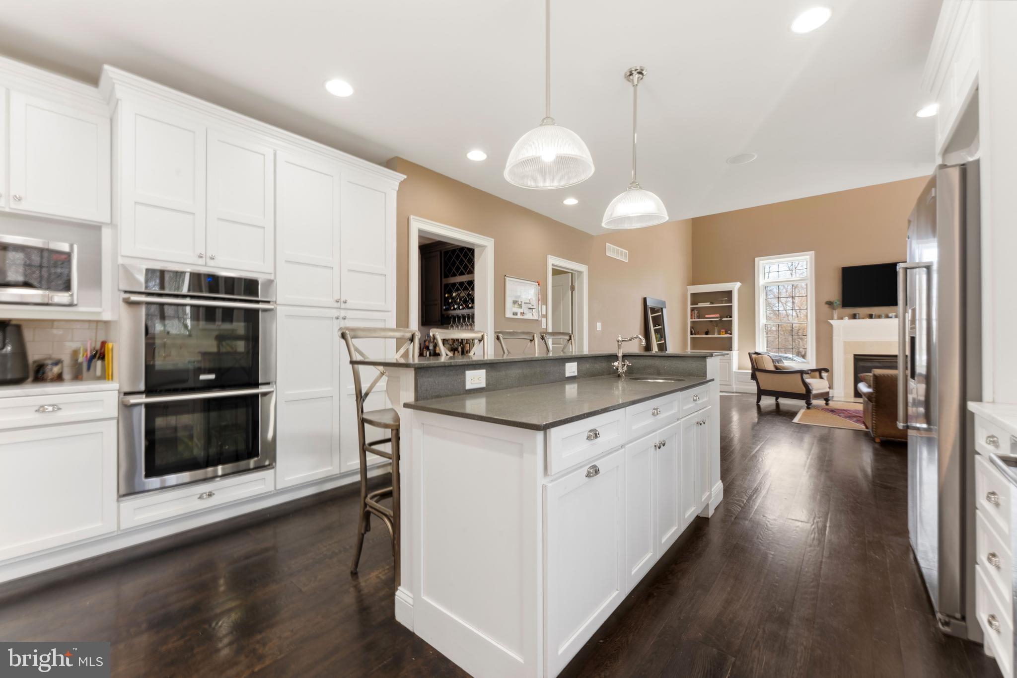 8 Quartermaster Road Feasterville-Trevose, PA 19053 - Photo 11 of 60 a kitchen with stainless steel appliances kitchen island granite countertop a stove a sink a refrigerator and white cabinets with wooden floor