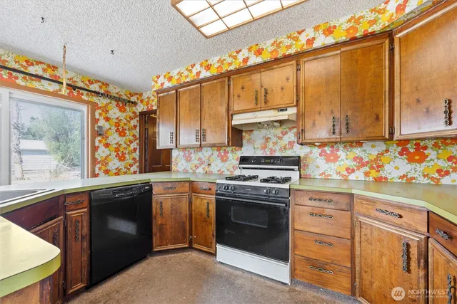 a kitchen with granite countertop a stove sink and cabinets