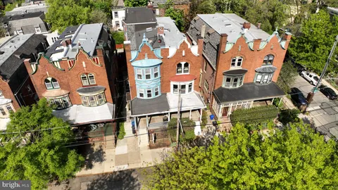 an aerial view of residential houses with outdoor space and parking