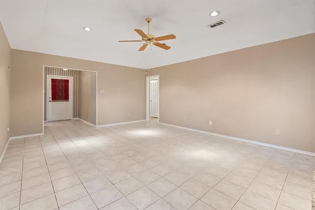 an empty room with windows and fan