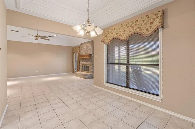 a view of a livingroom with a chandelier fan and windows