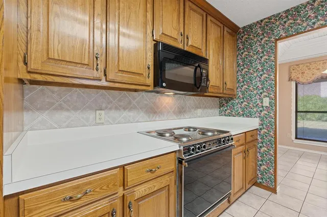 a kitchen with granite countertop cabinets stainless steel appliances and wooden cabinets