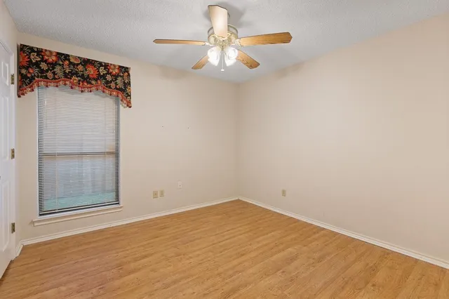 a view of a room with wooden floor and chandelier fan