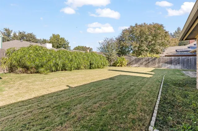 a view of a house with backyard and trees