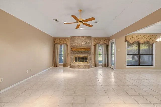 a view of an empty room with a fireplace and a window