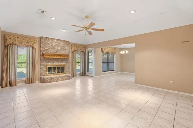 a view of an empty room with a fireplace and a window