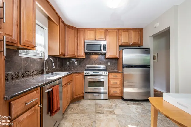 a kitchen with stainless steel appliances granite countertop a stove a sink and a microwave