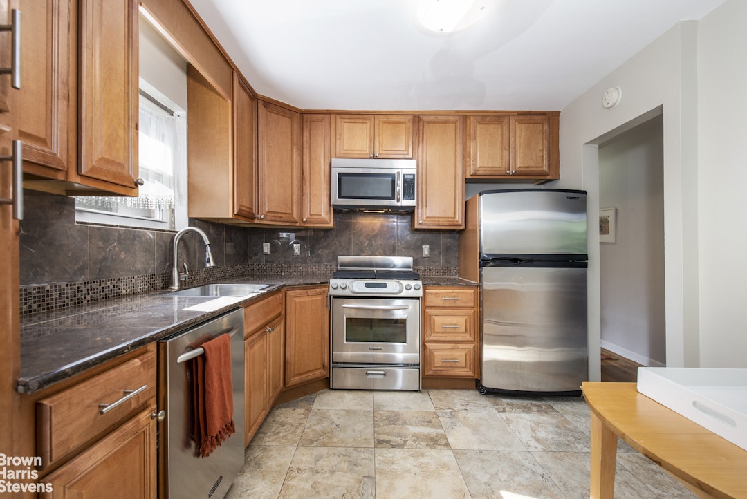 5834 Fieldston Road Bronx, NY 10471 - Photo 7 of 15 a kitchen with stainless steel appliances granite countertop a refrigerator stove and oven