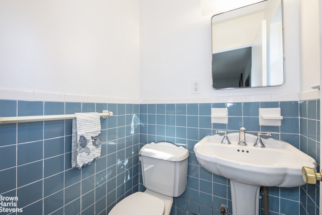 5834 Fieldston Road Bronx, NY 10471 - Photo 9 of 15 a bathroom with a sink a toilet and mirror