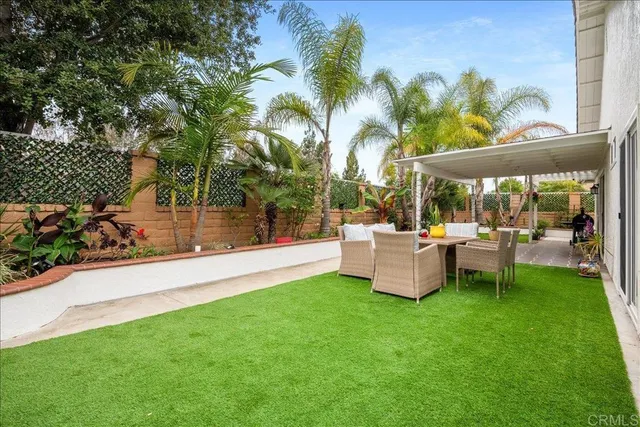 a view of a patio with table and chairs potted plants and palm tree