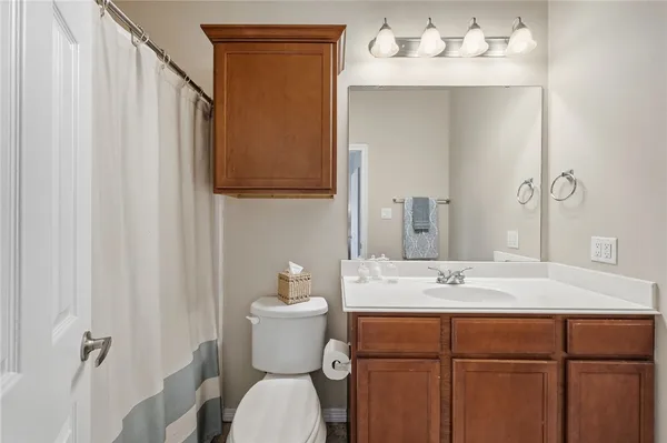 a bathroom with a sink mirror vanity and toilet