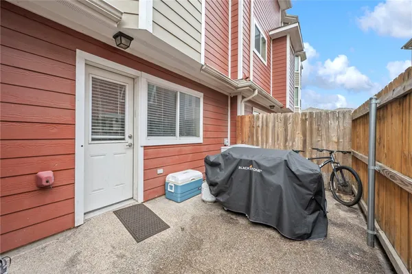a view of a house with a barbeque and wooden stairs