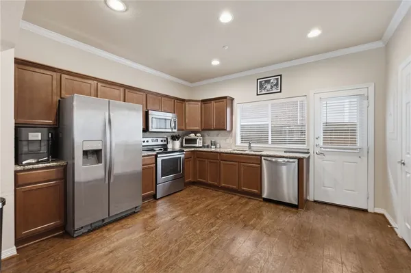 a kitchen with granite countertop white cabinets and stainless steel appliances