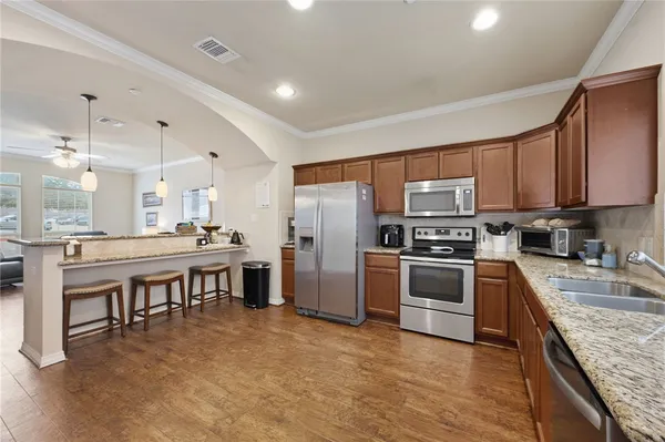 a kitchen with stainless steel appliances granite countertop a refrigerator stove microwave and sink