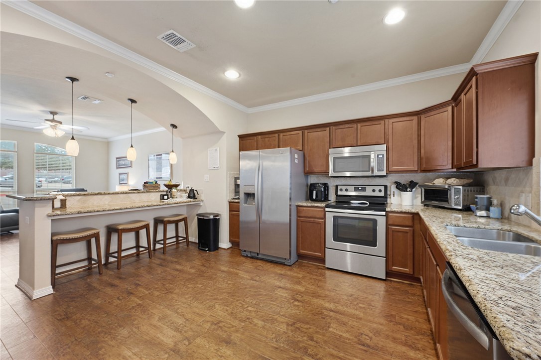 1198 Jones-Butler Road, Unit 2505 College Station, TX 77840 - Photo 5 of 13 a kitchen with stainless steel appliances granite countertop a refrigerator stove microwave and sink
