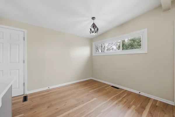 a view of a room with wooden floor and window