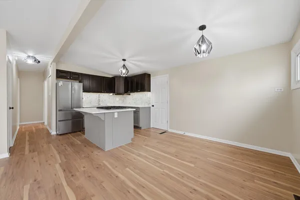 a large kitchen with a wooden floor and stainless steel appliances