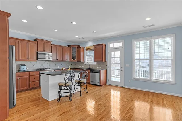 a kitchen with stainless steel appliances granite countertop a stove top oven a sink a counter space and cabinets